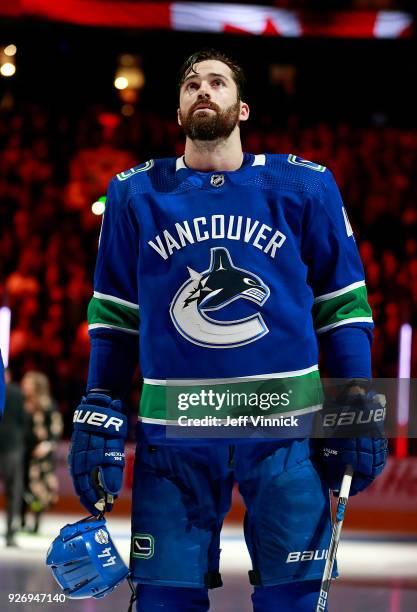 Erik Gudbranson of the Vancouver Canucks listens to the national anthem during their NHL game against the New York Rangers at Rogers Arena February...