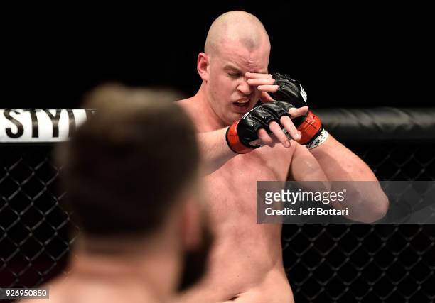Stefan Struve of The Netherlands reacts after being poked in the eye by Andrei Arlovski of Belarus in their heavyweight bout during the UFC 222 event...