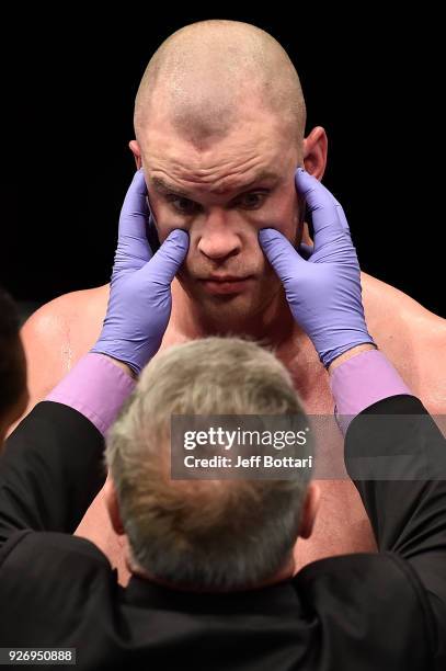 Stefan Struve of The Netherlands is checked by the doctor after being poked in the eye by Andrei Arlovski of Belarus in their heavyweight bout during...