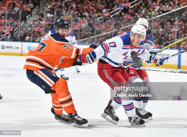 Oscar Klefbom of the Edmonton Oilers battles for the puck against Jesper Fast of the New York Rangers on March 3, 2018 at Rogers Place in Edmonton,...