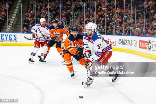 Iiro Pakarinen of the Edmonton Oilers harasses David Desharnais of the New York Rangers at Rogers Place on March 3, 2018 in Edmonton, Canada.