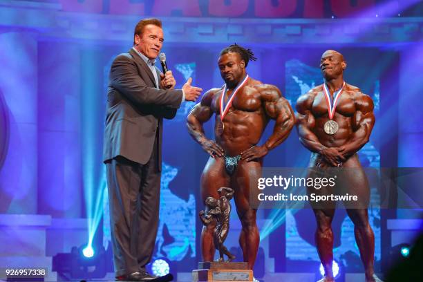 Arnold Schwarzenegger interviews Arnold Classic champion William Bonac as second place finisher Dexter Jackson looks on after Bonac won the Arnold...