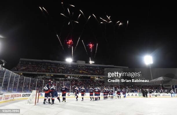The Washington Capitals skate over to and congratulate goaltender Braden Holtby after their 5-2 win against the Toronto Maple Leafs while fireworks...