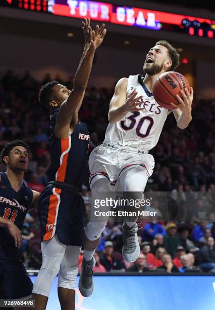 Jordan Ford of the Saint Mary's Gaels drives to the basket against Jade' Smith of the Pepperdine Waves during a quarterfinal game of the West Coast...