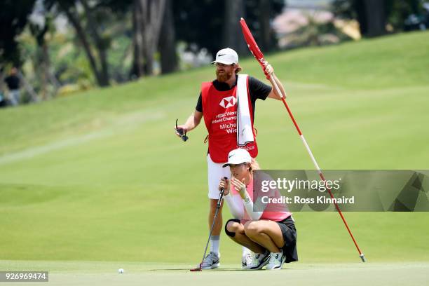 Michelle Wie of the United States and hr caddie line up her putt for birdie on her way to winning during the final round of the HSBC Women's World...