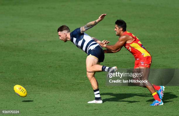 Zach Tuohy of the Cats and Aaron Hall of the Suns contest the ball during the AFL JLT Community Series match between the Geelong Cats and the Gold...