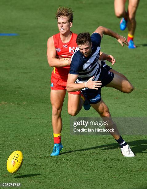 Jordan Murdoch of the Cats contests the ball with Darcy Macpherson of the Suns during the AFL JLT Community Series match between the Geelong Cats and...