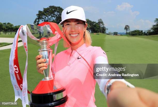 Michelle Wie of the United States celebrates with the winner's trophy after the final round of the HSBC Women's World Championship at Sentosa Golf...