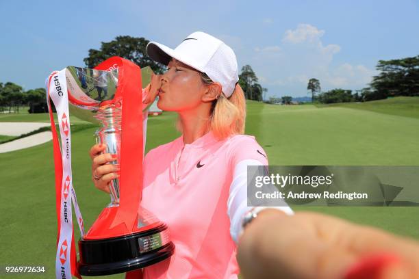 Michelle Wie of the United States celebrates with the winner's trophy after the final round of the HSBC Women's World Championship at Sentosa Golf...