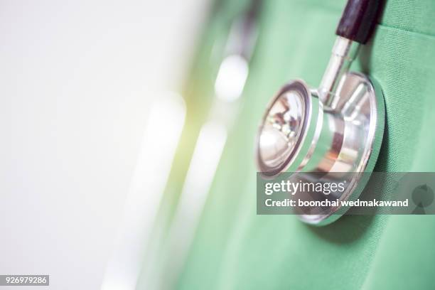 close up of professional male doctor in green gown with stethoscope, focus on stethoscope.isolated on white with copy space - medical equipment stock-fotos und bilder