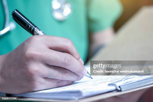 hand of doctor writing on prescription - register bildbanksfoton och bilder