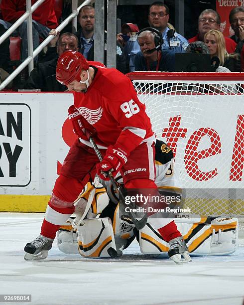 Tomas Holmstrom of the Detroit Red Wings look for the loose puck as Tim Thomas of the Boston Bruins gets into position during a NHL game at Joe Louis...