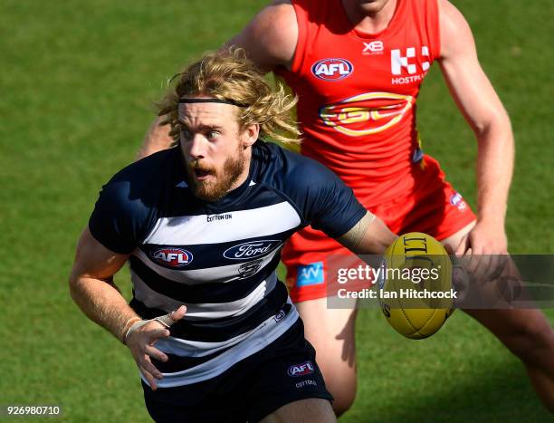 Cameron Guthrie of the Cats runs the ball during the AFL JLT Community Series match between the Geelong Cats and the Gold Coast Suns at Riverway...