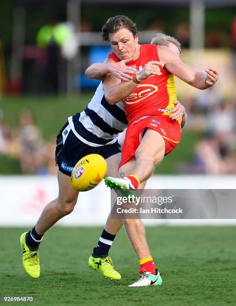 Nick Holman of the Suns is tackled by Zach Guthrie of the Cats during the AFL JLT Community Series match between the Geelong Cats and the Gold Coast...