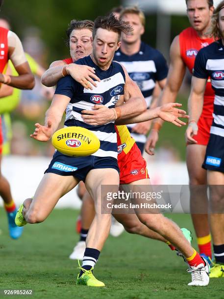 Jordan Cunico of the Cats is tackled by Nick Holman of the Suns during the AFL JLT Community Series match between the Geelong Cats and the Gold Coast...