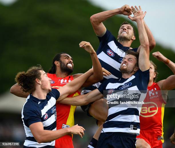 Jordan Murdoch and Wylie Buzza of the Cats contest the ball with Tom Nicholls of the Suns during the AFL JLT Community Series match between the...