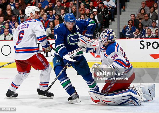Ryan Kesler of the Vancouver Canucks battles for position in front of the net against Wade Redden of the New York Rangers and teammate Henrik...