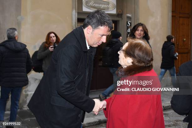 Former Prime Minister and leader of the Democratic Party , Matteo Renzi shakes hands to a woman outside a polling station on March 4, 2018 in...