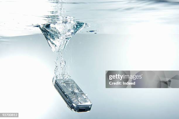 mobile phone falling into water - man made object imagens e fotografias de stock