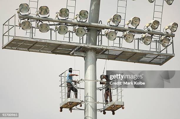 Workers attend to floodlights before an Australian nets session at Rajiv Gandhi International Cricket Stadium on November 4, 2009 in Hyderabad, India.