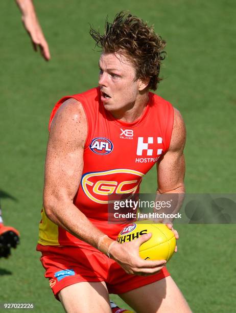 Nick Holman of the Suns runs the ball during the AFL JLT Community Series match between the Geelong Cats and the Gold Coast Suns at Riverway Stadium...