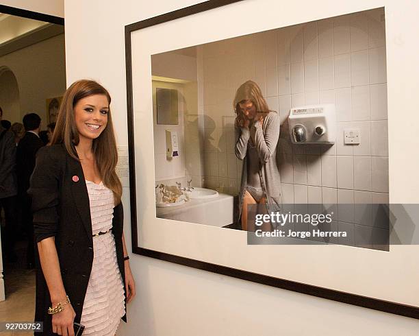 Photographer Ali Lomas, winner of the Godfrey Argent Award and the inaugural ELLE Commission, poses next to her winning photograph during the award...