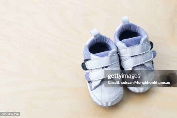 baby shoes on wooden background - zapatos marrones fotografías e imágenes de stock