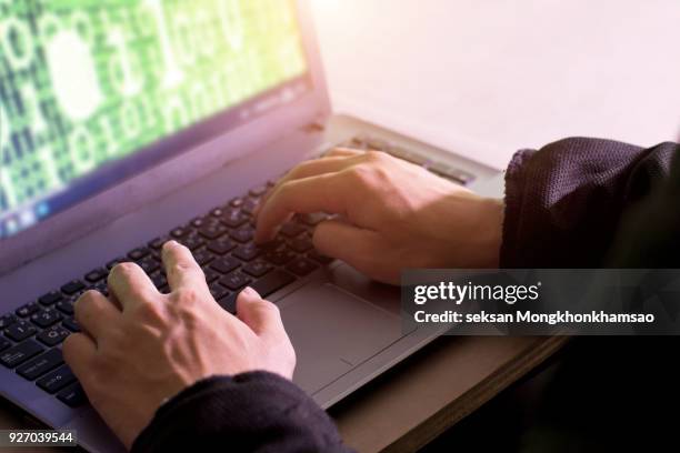 cyber crime hand reaching out through laptop computer and attack signifying in internet theft while using online banking, payment security concept - linux fotografías e imágenes de stock