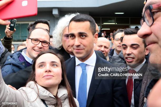Italy's populist Five Star Movement party leader Luigi Di Maio poses with supporters after voting for general elections on March 4, 2018 at a polling...
