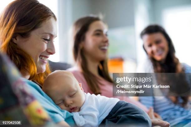 smiling mother with son by female friends at home - young adult with parents stock pictures, royalty-free photos & images