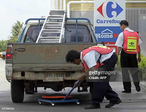 Members of Carrefour security personnel check a vehicle at the main entrance of the Carrefour supermarket in Hat Yai, southern of Thailand, 05 April...