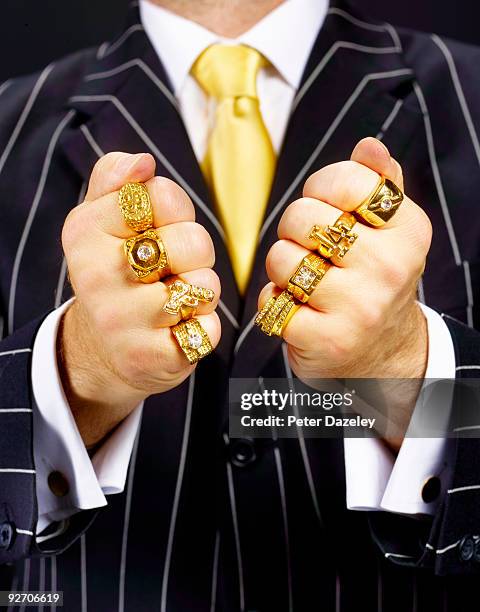 criminal in suit wearing gold rings. - showing off stock-fotos und bilder