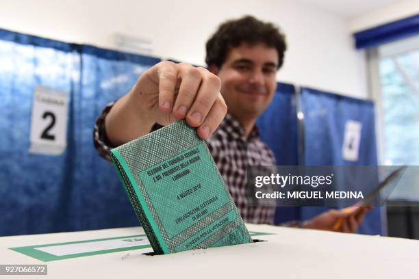 Polling advisor casts a ballot on March 4, 2018 at a polling station in Milan. - Italians vote today in one of the country's most uncertain...