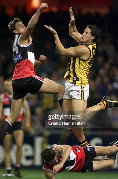 Lenny Hayes of St Kilda is knocked to the ground after Justin Koschitzke of St Kilda spoils an attempted mark by Trent Croad of Hawthorn, in the...