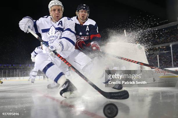 Leo Komarov of the Toronto Maple Leafs and Nicklas Backstrom of the Washington Capitals battle for the puck during the third period in the Coors...