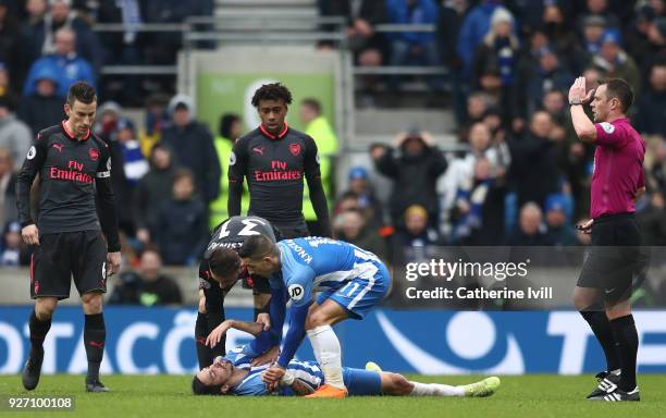 An injured Matias Ezequiel Schelotto of Brighton and Hove Albion lays on the ground after a clash with Sead Kolasinac of Arsenal during the Premier...