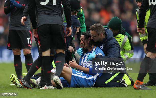 An injured Matias Ezequiel Schelotto of Brighton and Hove Albion goes off following a clash with Sead Kolasinac of Arsenal during the Premier League...