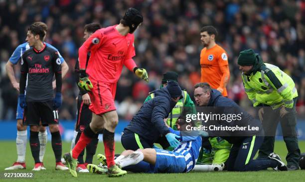 An injured Matias Ezequiel Schelotto of Brighton and Hove Albion goes off following a clash with Sead Kolasinac of Arsenal during the Premier League...