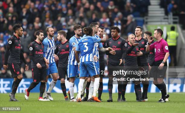 Players from both sides surround the referee following a clash between Matias Ezequiel Schelotto of Brighton and Hove Albion and Sead Kolasinac of...
