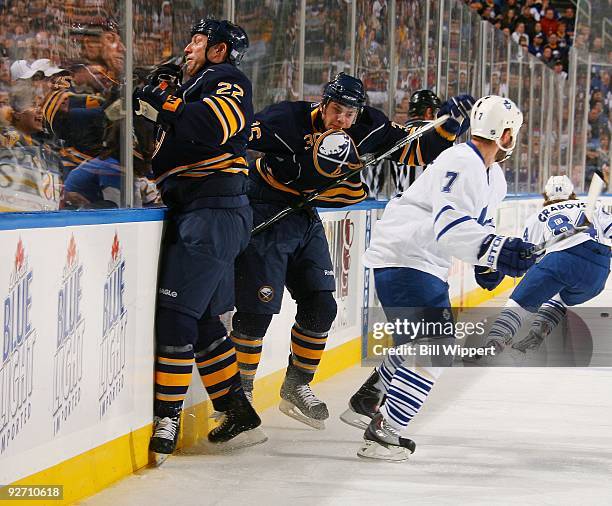 Adam Mair and Patrick Kaleta of the Buffalo Sabres crash into the boards trying to check Ian White of the Toronto Maple Leafs on October 30, 2009 at...