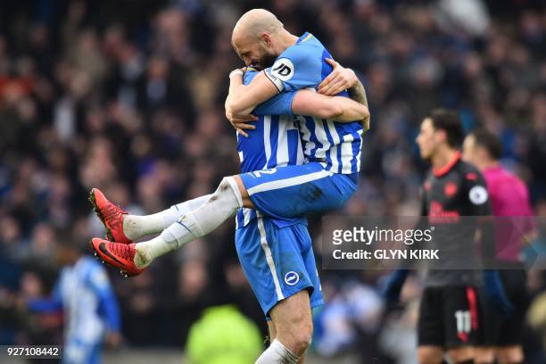 Brighton's Spanish defender Bruno Saltor leaps into the arms of Brighton Irish defender Shane Duffy on the pitch after the English Premier League...