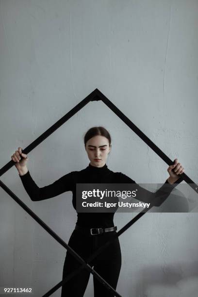 young woman standing with large picture frame - female models photo gallery stockfoto's en -beelden