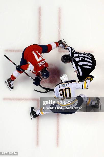 Linesmen Michel Cormier drops the puck for a face off between Derek MacKenzie of the Florida Panthers and Ryan O'Reilly of the Buffalo Sabres at the...