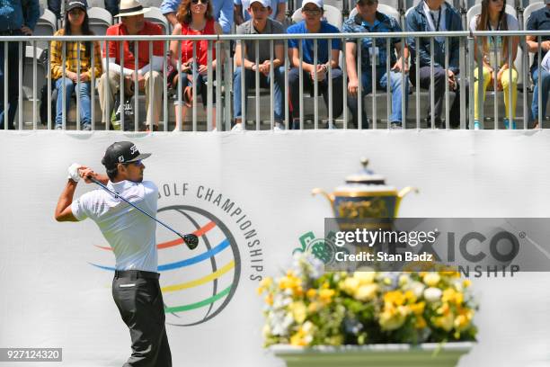 Fans watch Rafa Cabrera Bello of Spain hitting a tee shot on the first hole during round three of the World Golf Championships-Mexico Championship at...