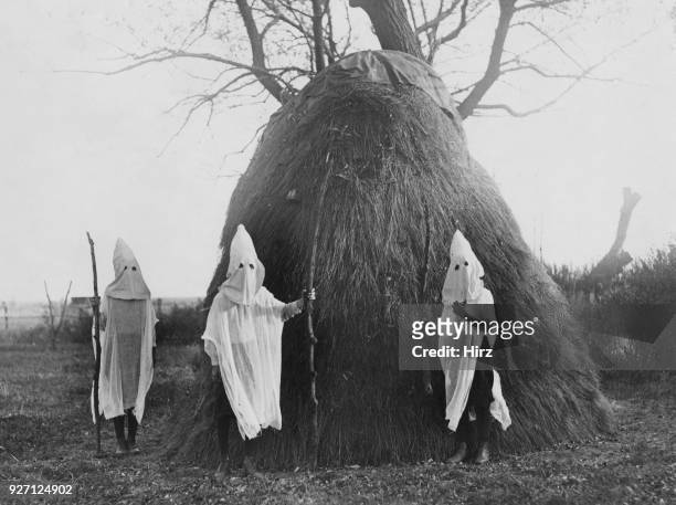 Three children mimicking the regalia and activities of the Ku Klux Klan, East Lots, Canarsie, Brooklyn, New York City, circa 1925. Calling themselves...