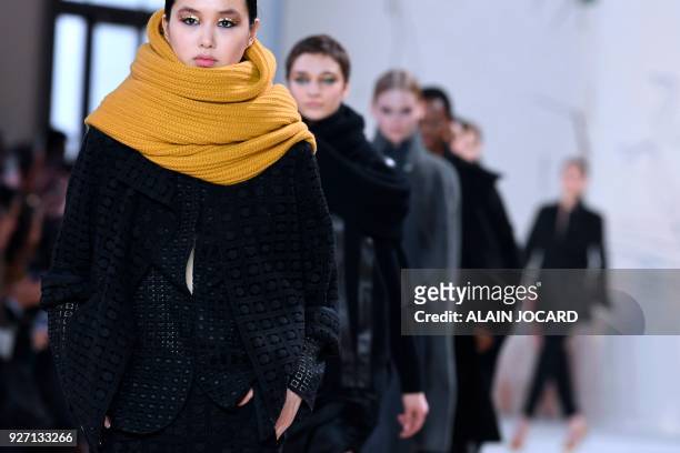Models present creations for Akris during the 2018/2019 fall/winter collection fashion show on March 4, 2018 in Paris.