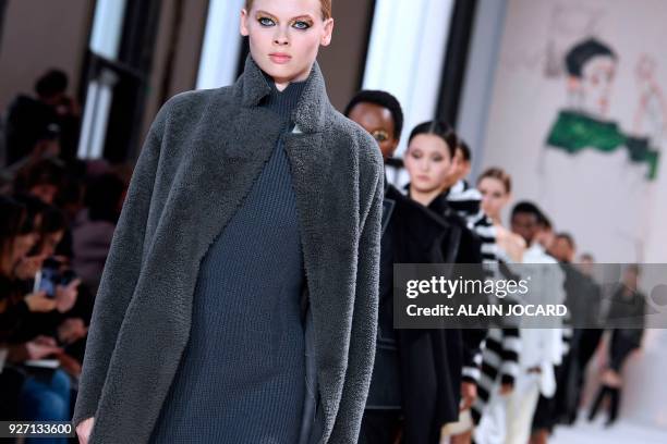 Models present creations for Akris during the 2018/2019 fall/winter collection fashion show on March 4, 2018 in Paris.