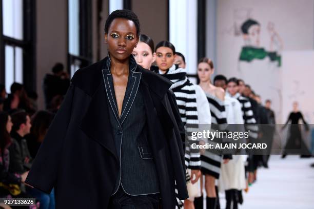 Models present creations for Akris during the 2018/2019 fall/winter collection fashion show on March 4, 2018 in Paris.