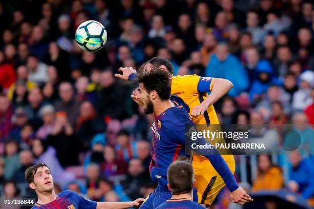 Barcelona's Portuguese midfielder Andre Gomes and Atletico Madrid's Uruguayan defender Diego Godin jump for the ball during the Spanish league...