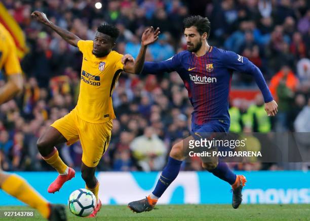 Barcelona's Portuguese midfielder Andre Gomes vies for the ball with Atletico Madrid's Ghanaian midfielder Thomas during the Spanish league football...